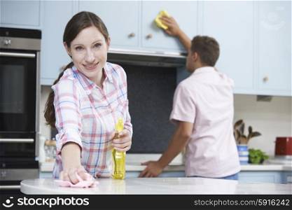 Couple Cleaning Kitchen Surfaces And Cupboards Together