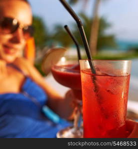 Couple clinking glasses with cocktails at poolside