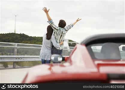 Couple close together near electric car