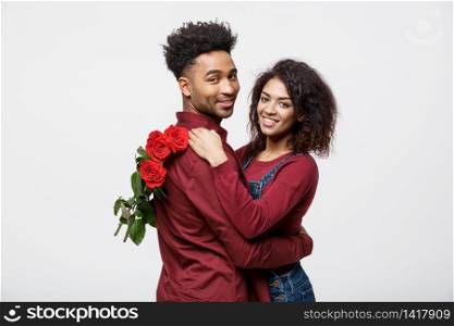 Couple Concept - Young african american couple huging each other and holding romantic red rose. Couple Concept - Young african american couple huging each other and holding romantic red rose.