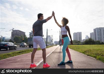 couple congratulating on morning run ginis young sporty mixed rase couple congratulating with hand five after successful morning jogging
