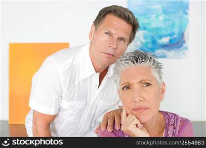 Couple contemplating paintings in gallery