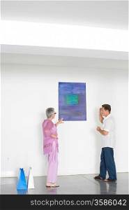 Couple contemplating paintings in gallery