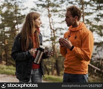 couple conversing hot beverage while road trip