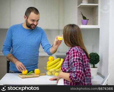 couple cooking food fruit lemon juice at kitchen. young pregnant couple cooking food fruit lemon juice at kitchen, lifestyle healthy pregnancy happy life concept