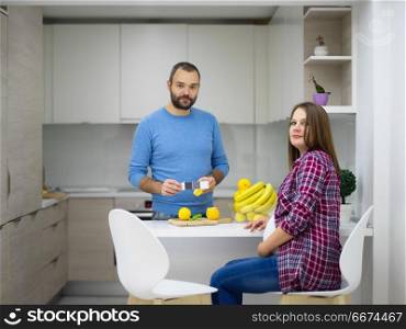 couple cooking food fruit lemon juice at kitchen. young pregnant couple cooking food fruit lemon juice at kitchen, lifestyle healthy pregnancy happy life concept