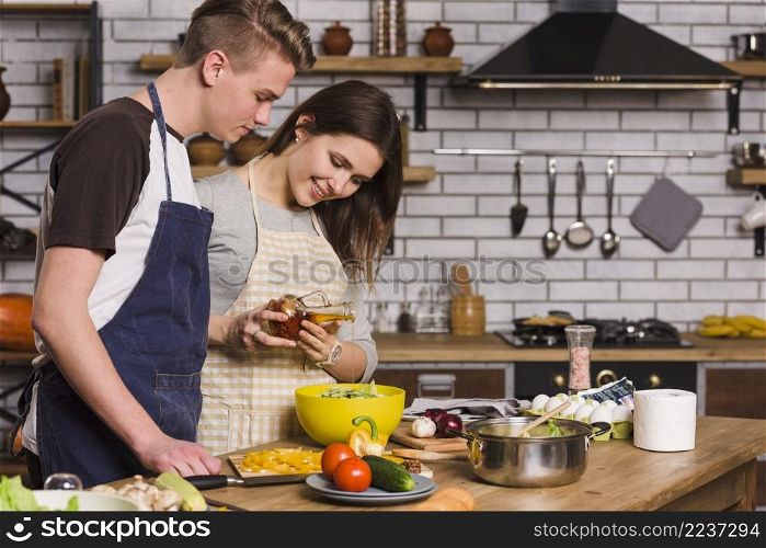 couple cooking vegetarian salad with fresh vegetables