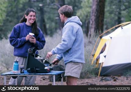 Couple Cooking While Camping