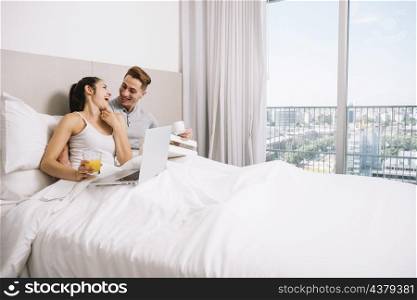 couple cuddling laughing bed morning
