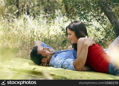 Couple cuddling on picnic blanket