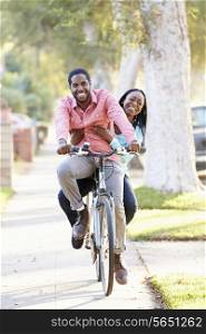 Couple Cycling Along Suburban Street Together