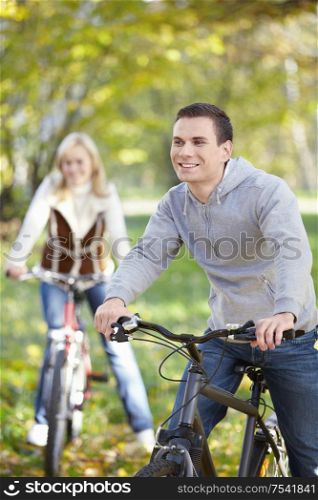 Couple cycling in autumn park