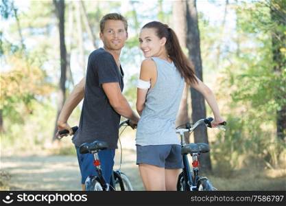 couple cycling in the forest