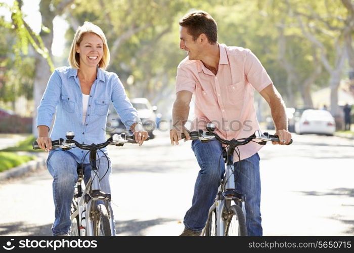 Couple Cycling On Suburban Street