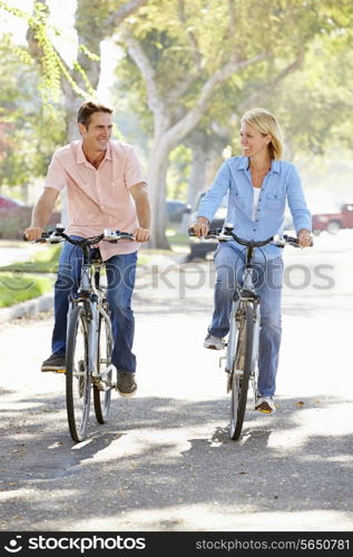 Couple Cycling On Suburban Street