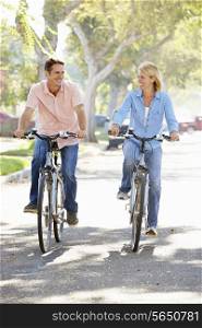 Couple Cycling On Suburban Street