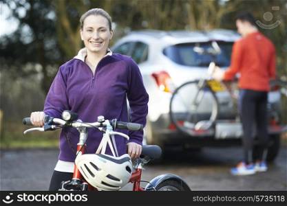 Couple Cycling Taking Mountain Bikes From Rack On Car