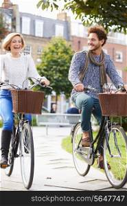 Couple Cycling Through Urban Park Together