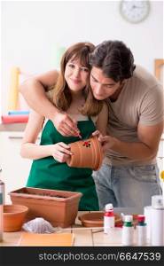 Couple decorating pots in workshop during class