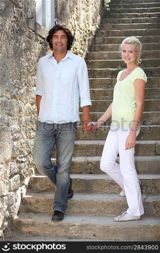 couple descending downstairs in an old village