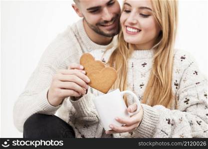 couple dipping cookies into mug