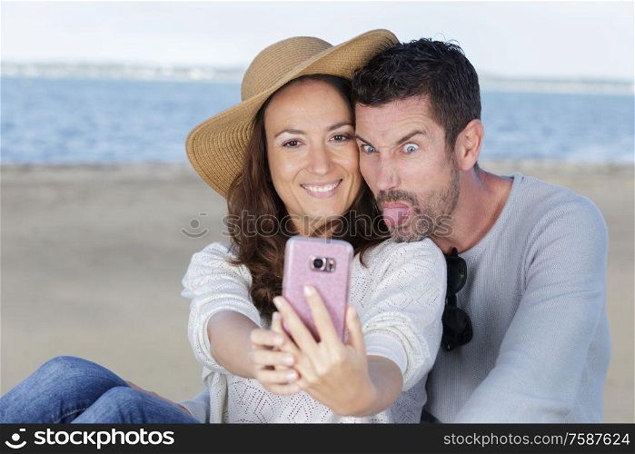 couple doing silly and funny faces while taking selfie picture