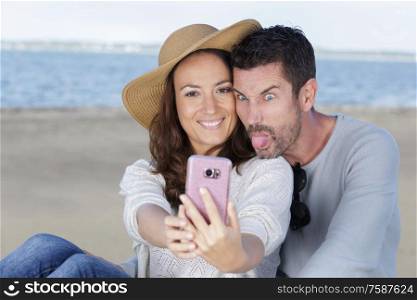 couple doing silly and funny faces while taking selfie picture