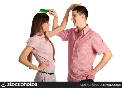 Couple dressed in pink clothes comb each others isolated on white