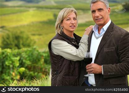Couple drinking a glass of wine in a vineyard