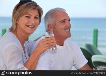 Couple drinking beer in beach terrace