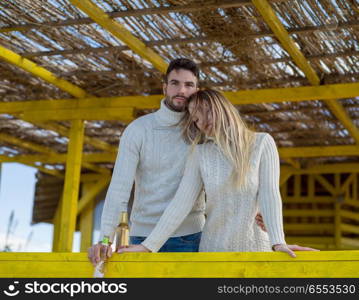 Couple Drinking Beer Together in empty beach bar during autumn time. young couple drinking beer together at the beach