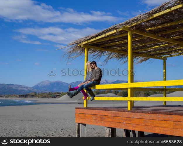 Couple Drinking Beer Together in empty beach bar during autumn time. young couple drinking beer together at the beach