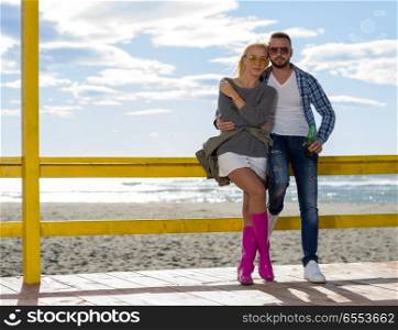 Couple Drinking Beer Together in empty beach bar during autumn time. young couple drinking beer together at the beach