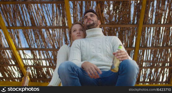 Couple Drinking Beer Together on beach during autumn time