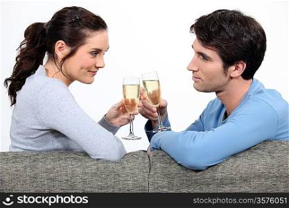 Couple drinking champagne on sofa