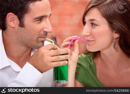 Couple drinking from the same glass