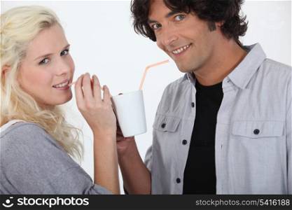 couple drinking together off same mug with straw