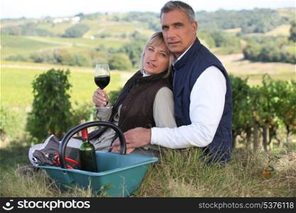 Couple drinking wine by vineyard