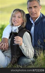 Couple drinking wine in field