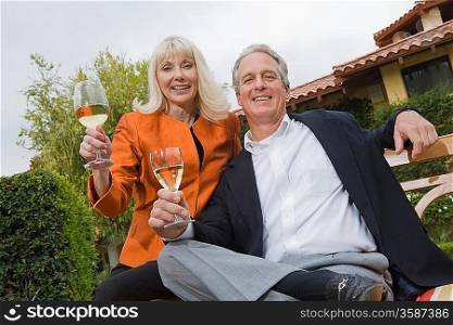 Couple drinking wine in garden, portrait