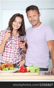 Couple drinking wine while fixing dinner