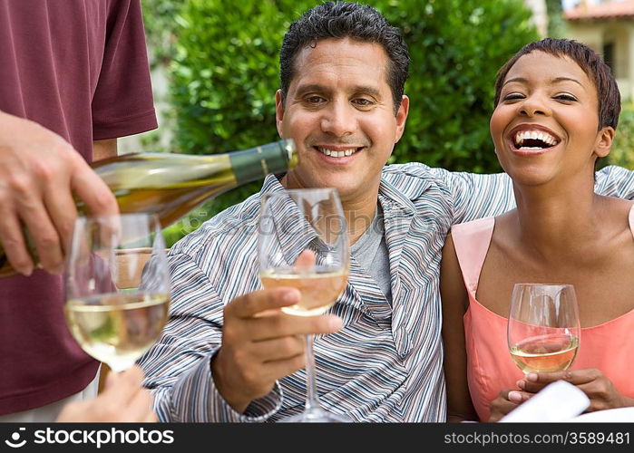 Couple drinking wine with friends outdoors
