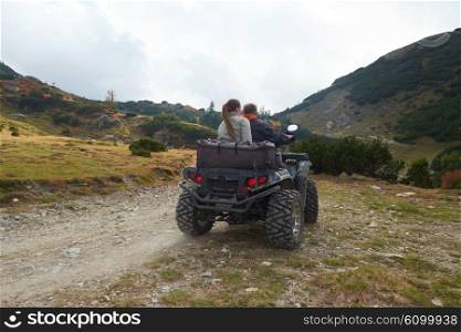 couple drive atv quad bike in mountain nature