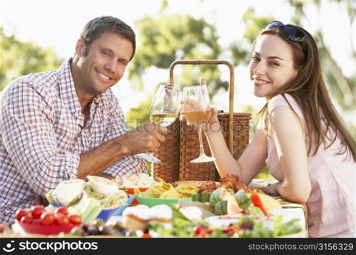 Couple Eating An Al Fresco Meal, Toasting With Wineglasses