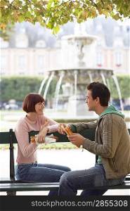 Couple Eating Baguettes in Park