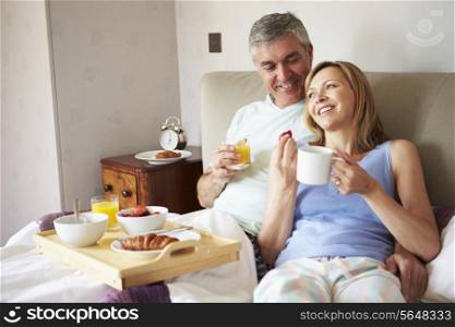 Couple Eating Breakfast In Bed Together