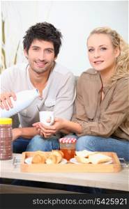 Couple eating breakfast on a sofa
