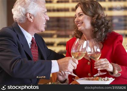 Couple Eating Dinner And Toasting With A Glass Of Wine
