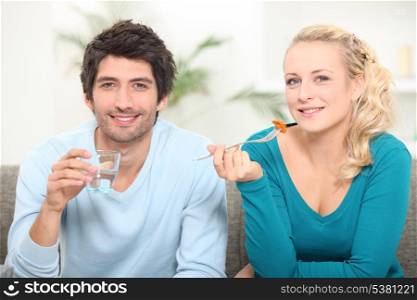 Couple eating lunch on the couch