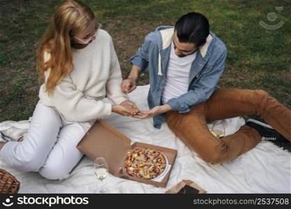 couple eating pizza outdoors